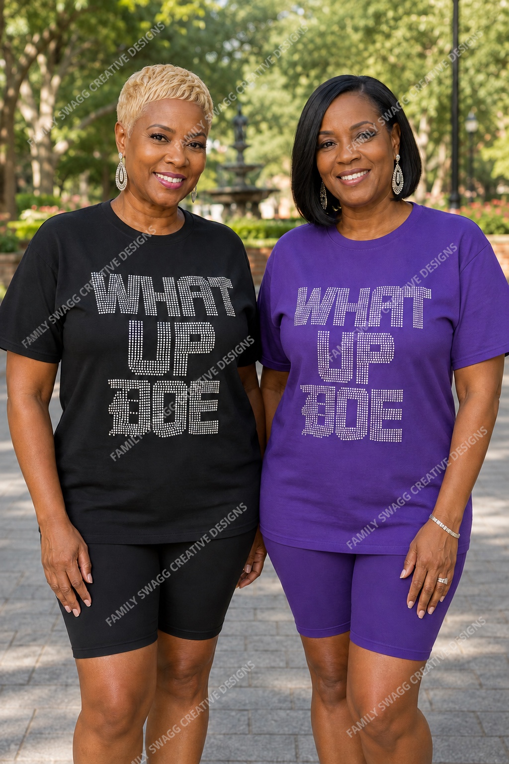Two mature African-American women modeling black and purple WHAT UP DOE iridescent rhinestone shirts outdoors