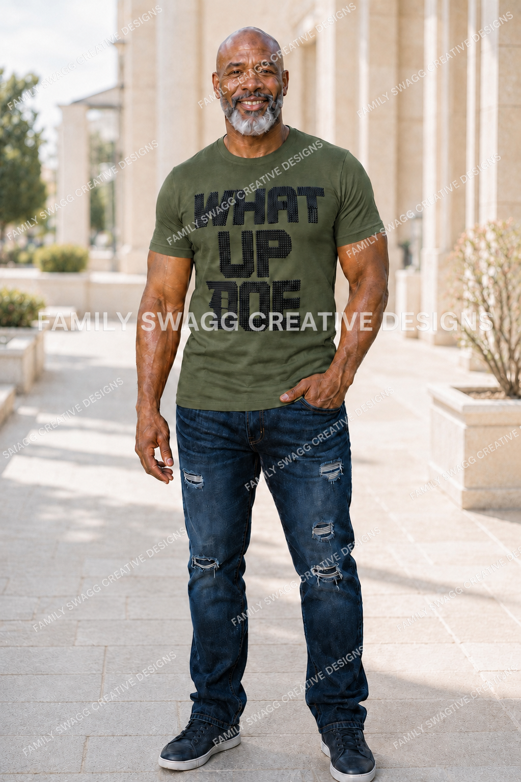 Mature African-American man modeling a fitted army-green WHAT UP DOE shirt with black rhinestones and distressed dark-navy jeans outdoors